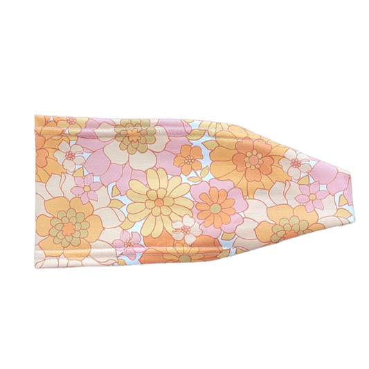 headband with small to large flowers in shades of light purple pink and orange